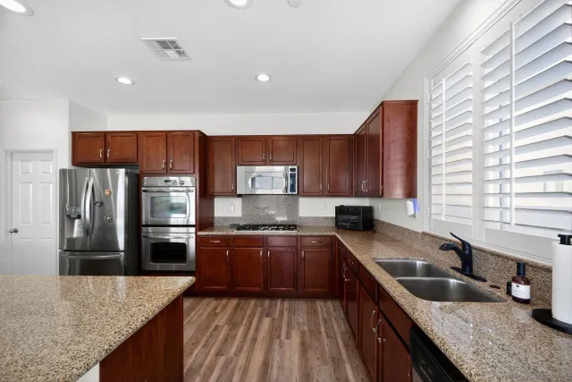 a kitchen with stainless steel appliances granite countertop a sink stove and refrigerator