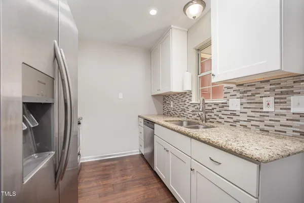 a kitchen with granite countertop a sink and a stove