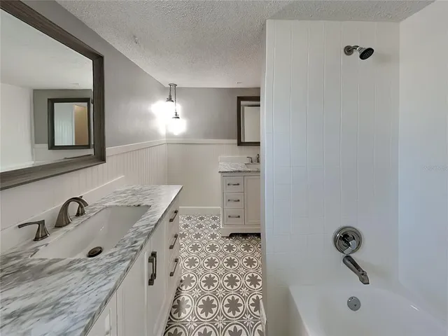 a bathroom with a tub sink and mirror