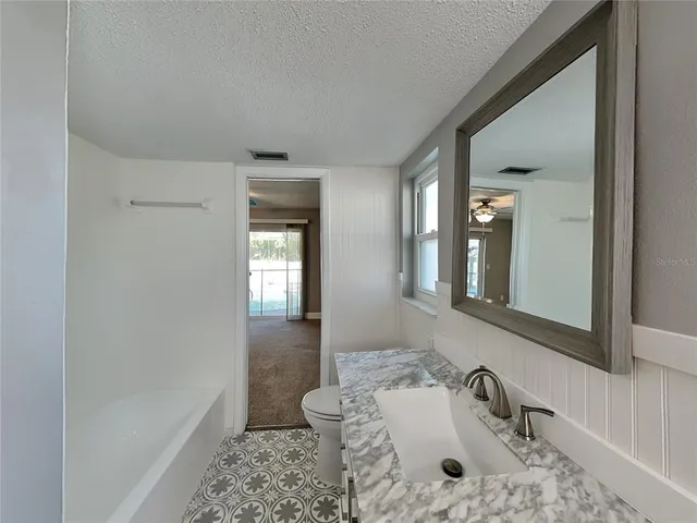 a bathroom with a tub sink and mirror