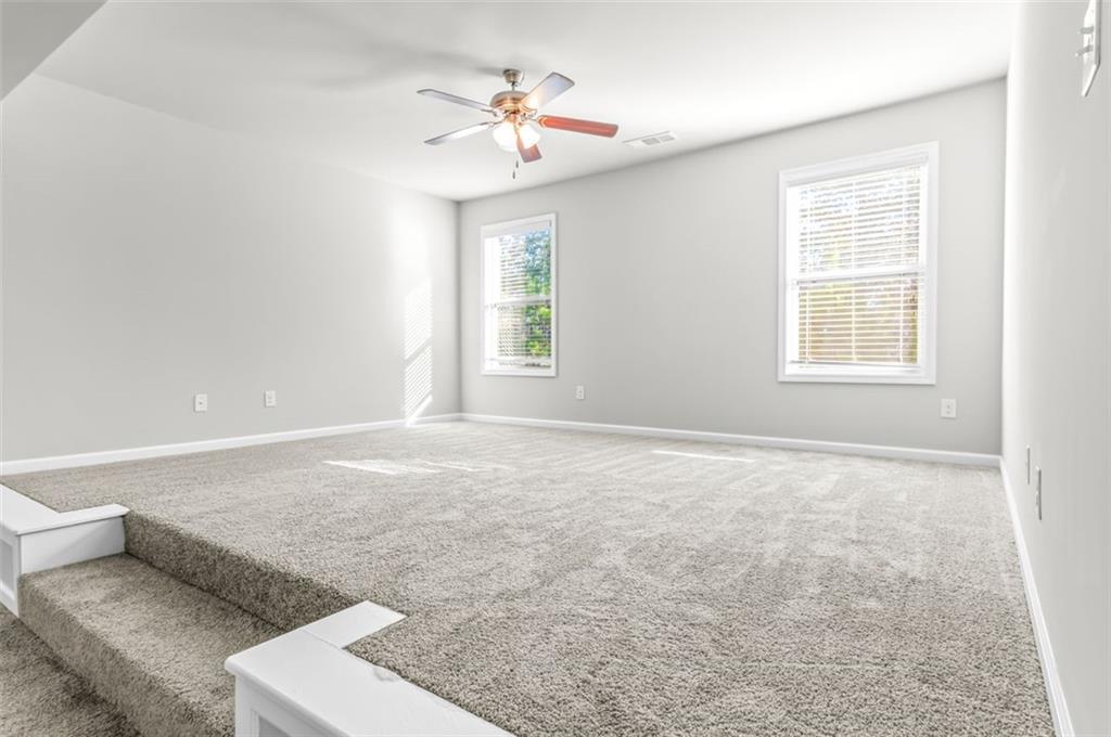 4237 Water Mill Drive Buford, GA 30519 - Photo 17 of 35 an empty room with windows and chandelier fan