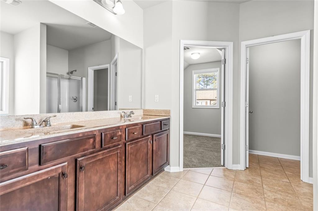 4237 Water Mill Drive Buford, GA 30519 - Photo 22 of 35 a spacious bathroom with a granite countertop sink and a mirror