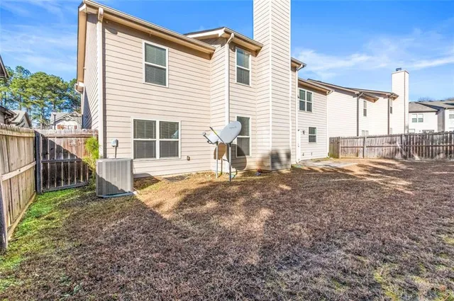 a view of a house with backyard and a tree
