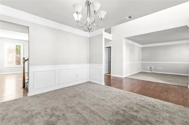 wooden floor in an empty room with a chandelier