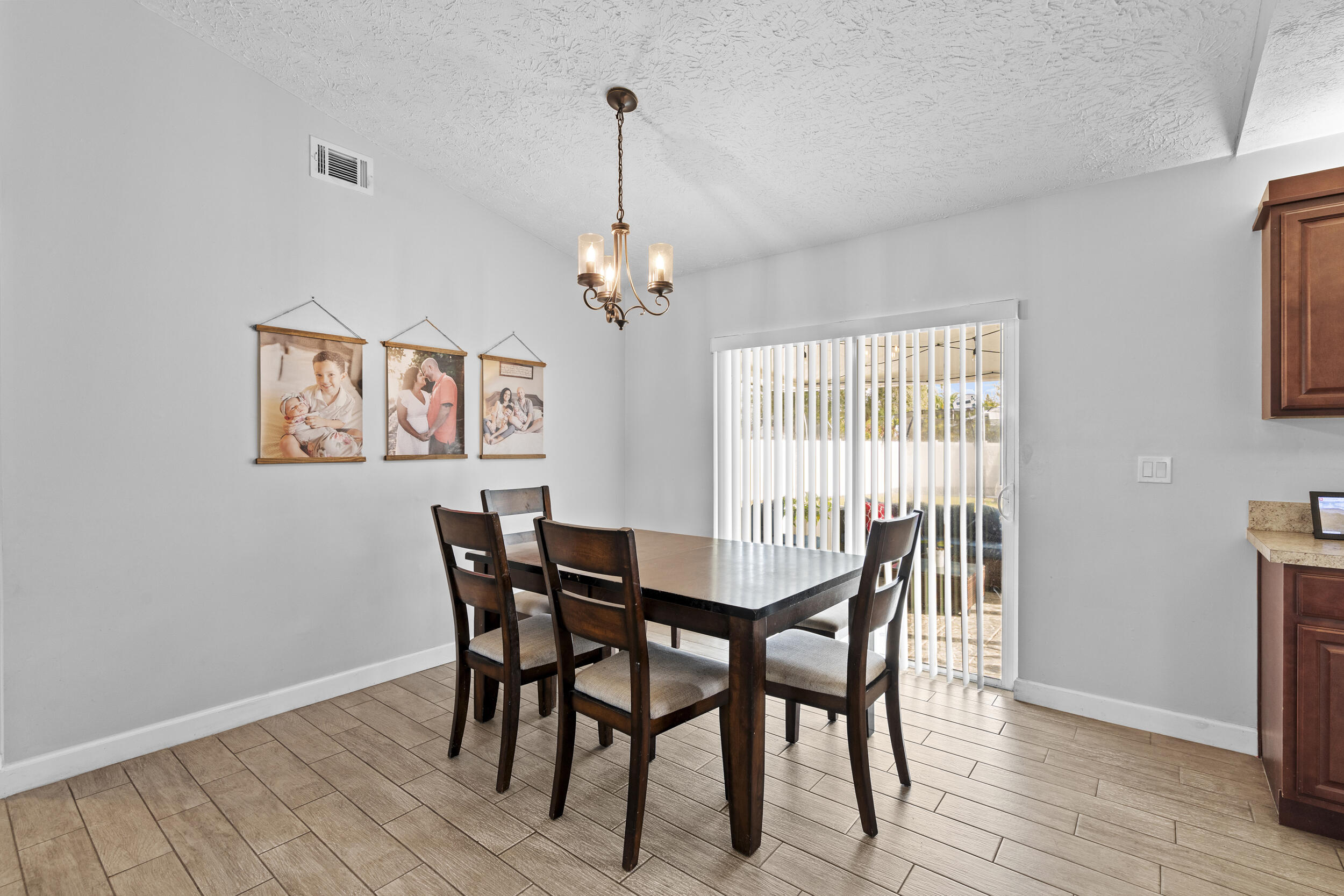 2121 Southeast Midtown Road Port St. Lucie, FL 34952 - Photo 13 of 42 a view of a dining room with furniture wooden floor and chandelier