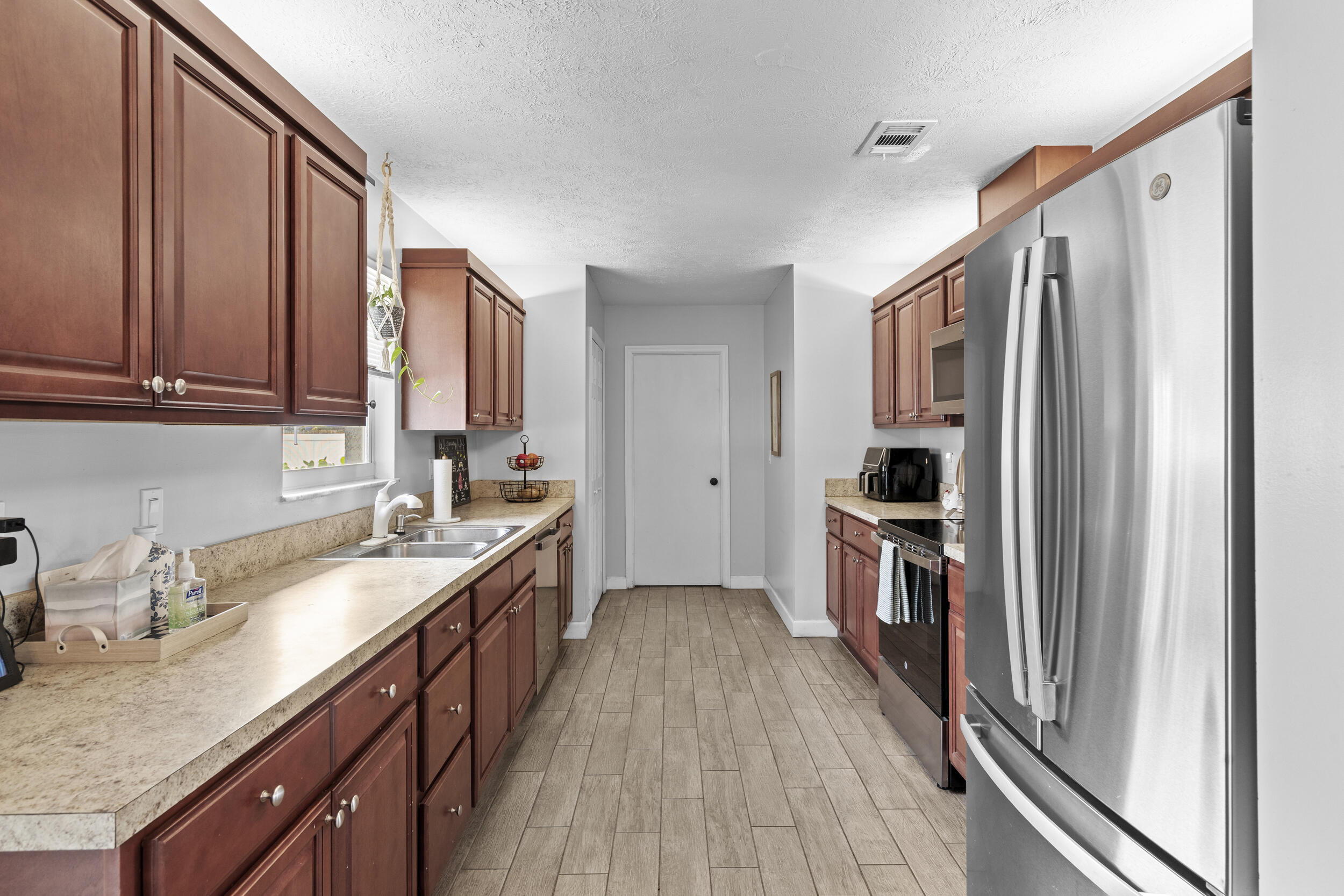 2121 Southeast Midtown Road Port St. Lucie, FL 34952 - Photo 15 of 42 a kitchen with granite countertop a sink stove and refrigerator