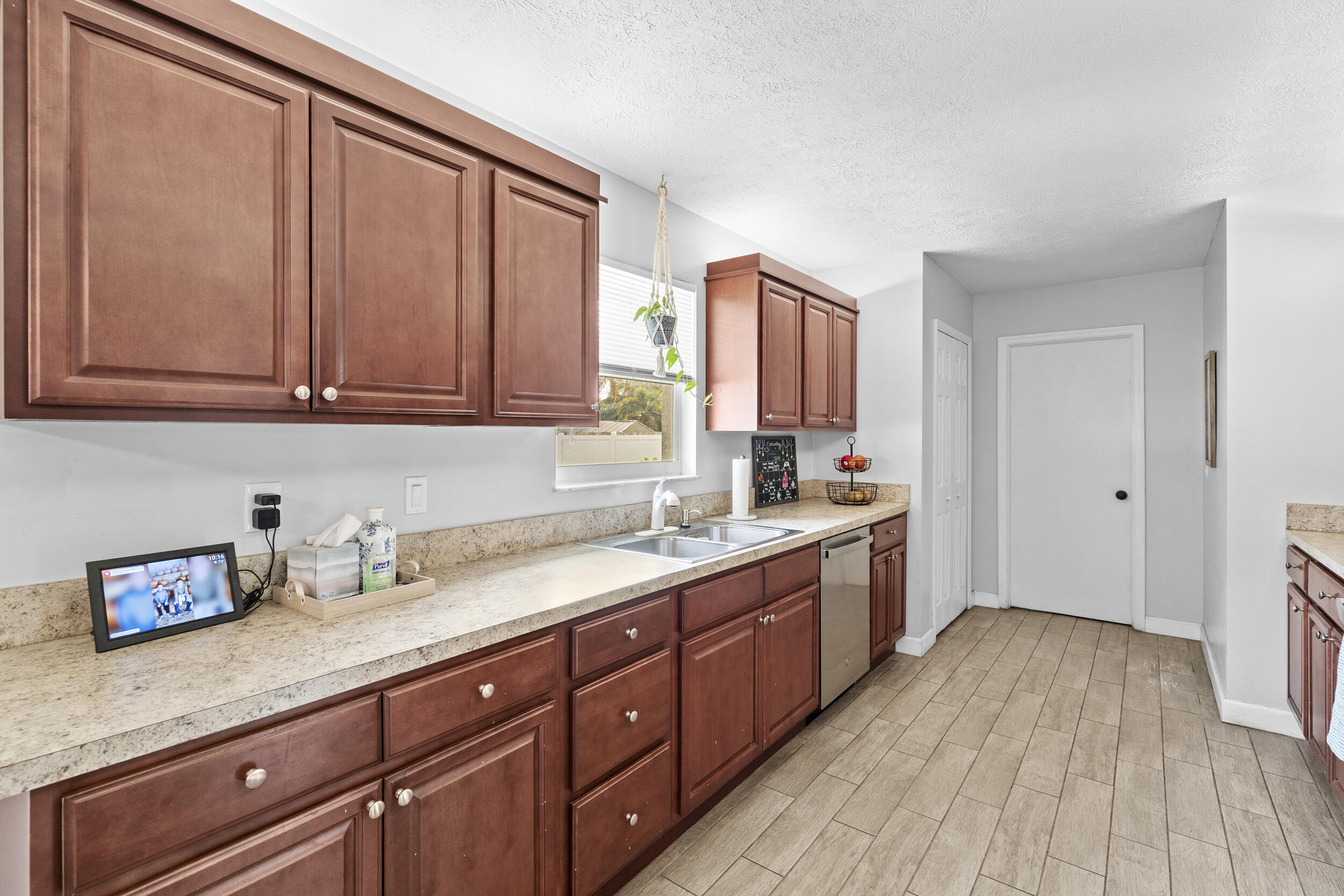 2121 Southeast Midtown Road Port St. Lucie, FL 34952 - Photo 16 of 42 a kitchen with stainless steel appliances granite countertop wooden cabinets a sink and dishwasher with wooden floor