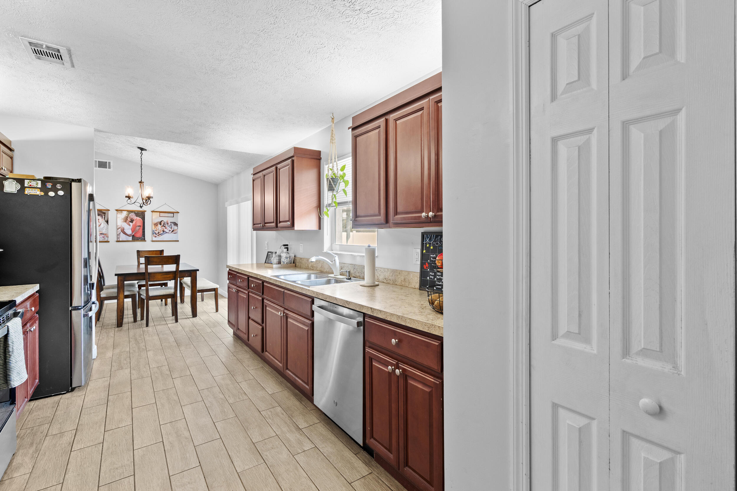 2121 Southeast Midtown Road Port St. Lucie, FL 34952 - Photo 17 of 42 a kitchen with stainless steel appliances granite countertop a stove a sink dishwasher and a refrigerator with wooden floor