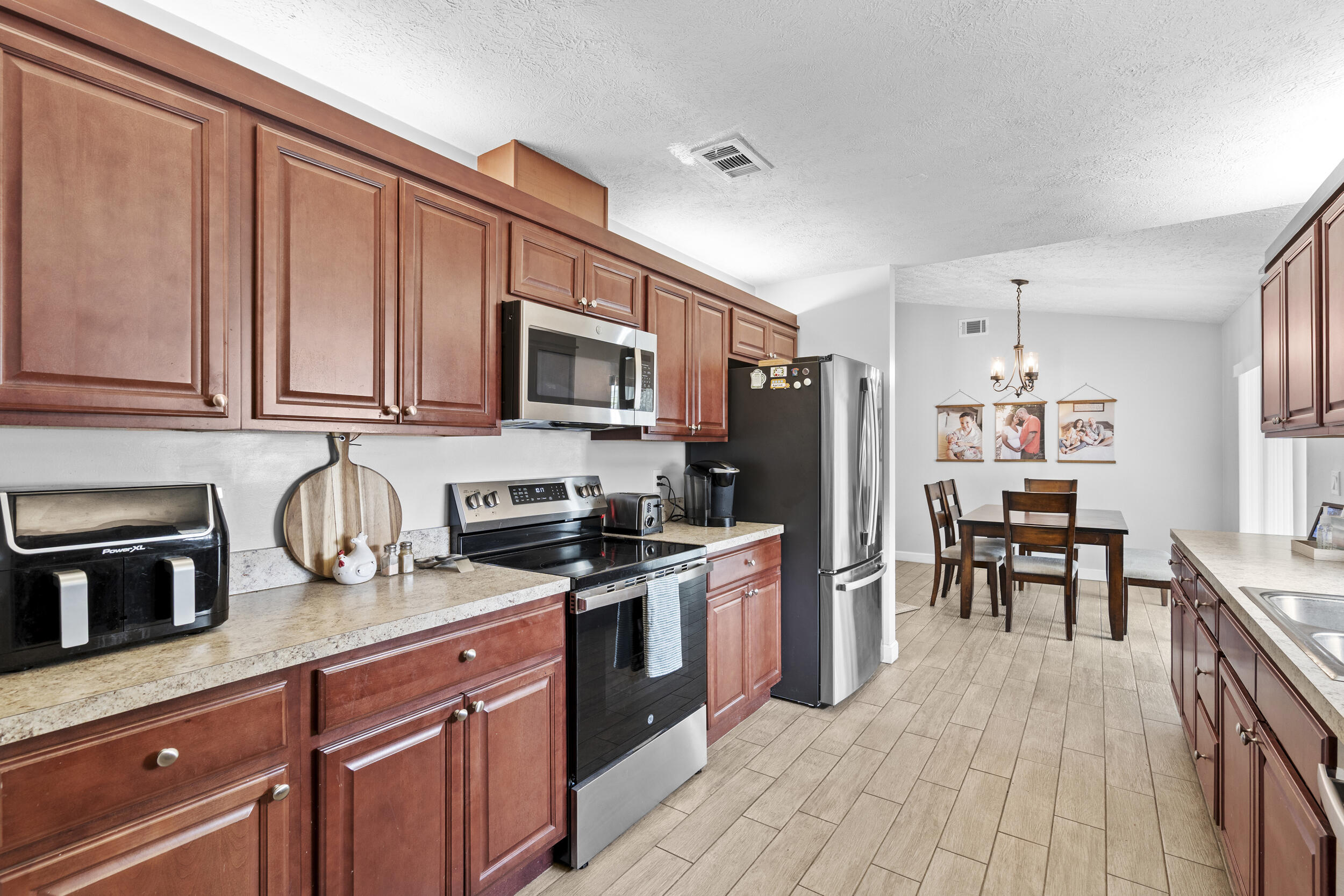 2121 Southeast Midtown Road Port St. Lucie, FL 34952 - Photo 18 of 42 a kitchen with stainless steel appliances granite countertop a refrigerator stove microwave and sink
