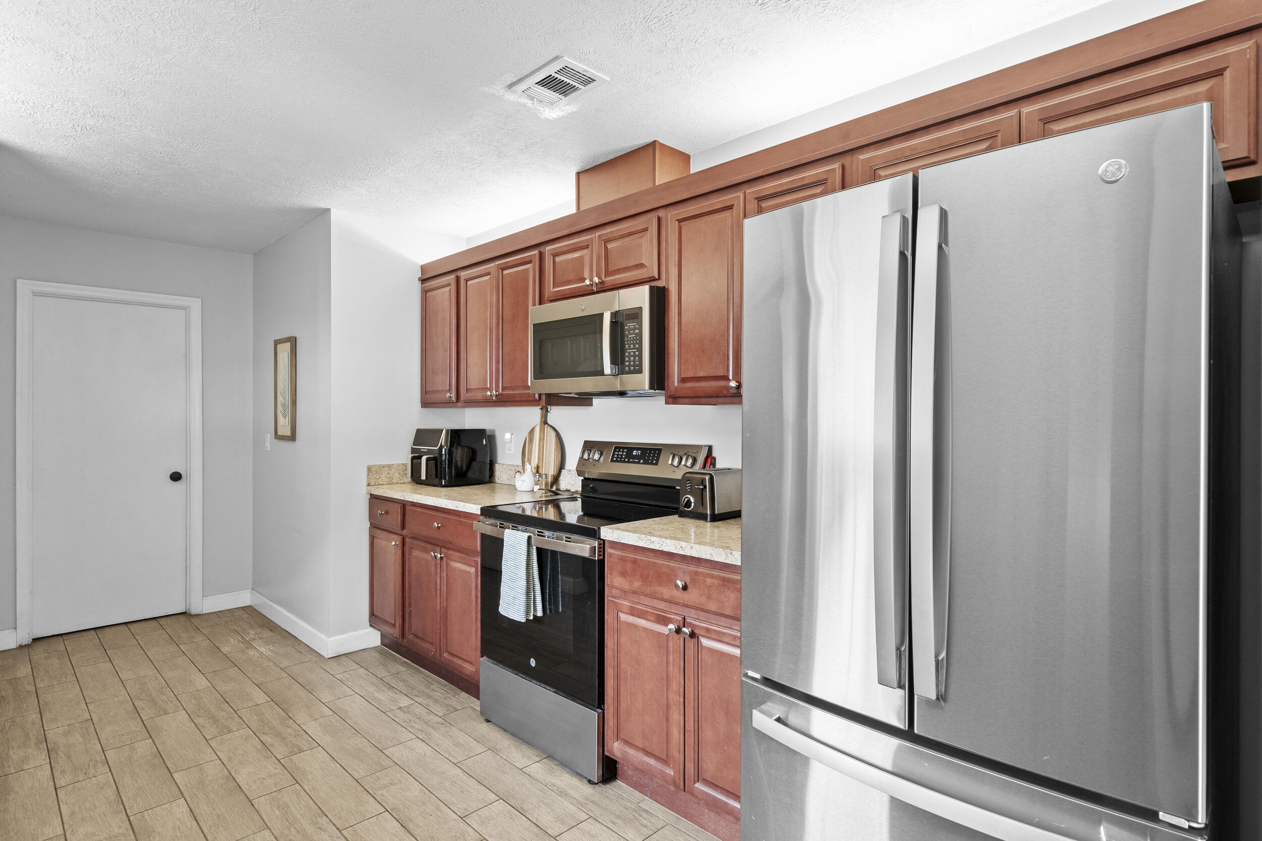 2121 Southeast Midtown Road Port St. Lucie, FL 34952 - Photo 19 of 42 a kitchen with stainless steel appliances a refrigerator stove and microwave