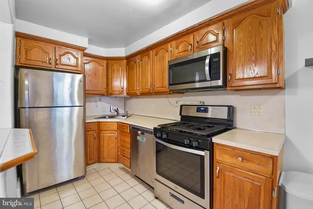 a kitchen with stainless steel appliances granite countertop a refrigerator stove top oven a sink and dishwasher