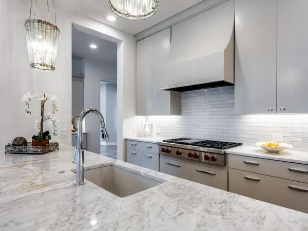 a kitchen with stainless steel appliances granite countertop a sink and a stove