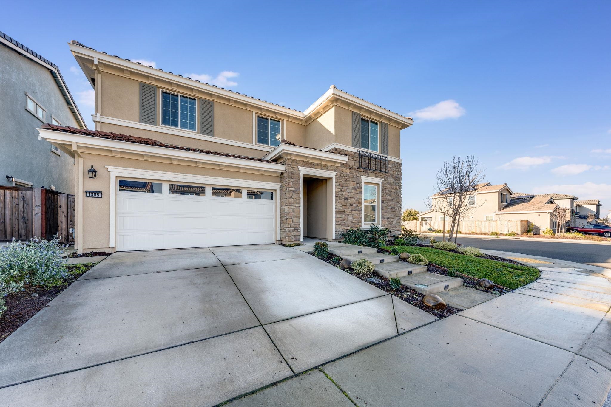 a front view of a house with a yard and a garage