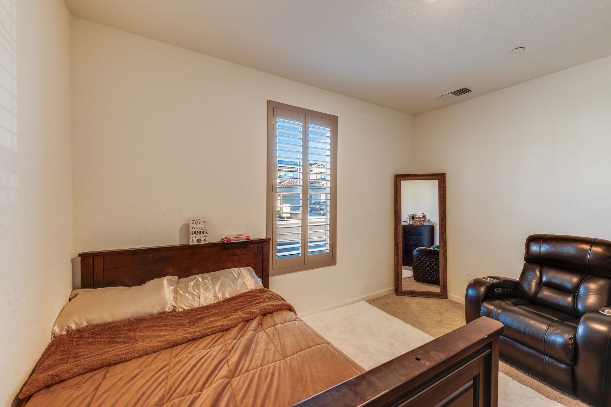 1305 Stark Bridge Road Lincoln, CA 95648 - Photo 10 of 53 a bed sitting in a bedroom next to a window with chair