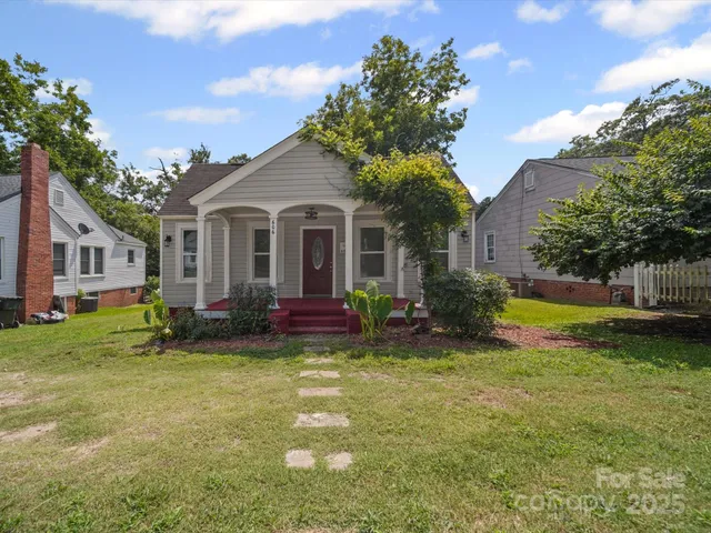 a view of a house with a patio and a yard