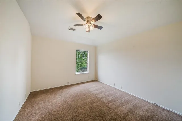 an empty room with a window and a ceiling fan