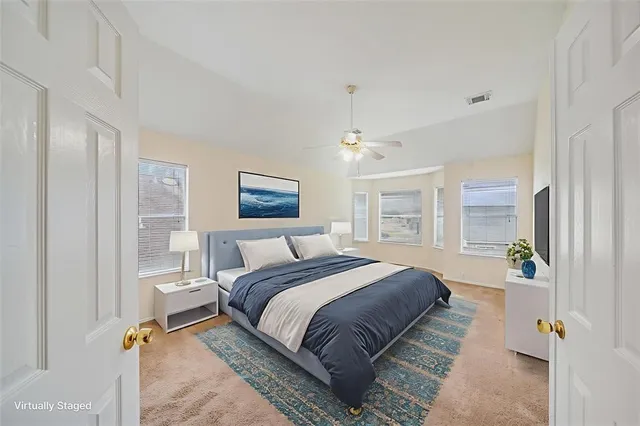 a spacious bedroom with a bed and a chandelier