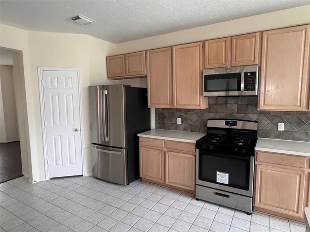 a kitchen with a refrigerator stove and microwave