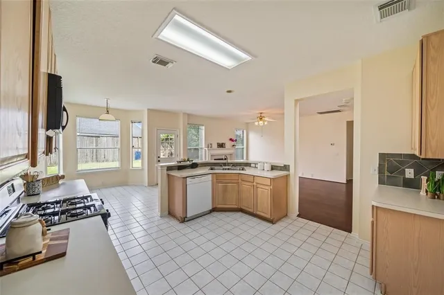 a large kitchen with a stove a sink dishwasher and a refrigerator