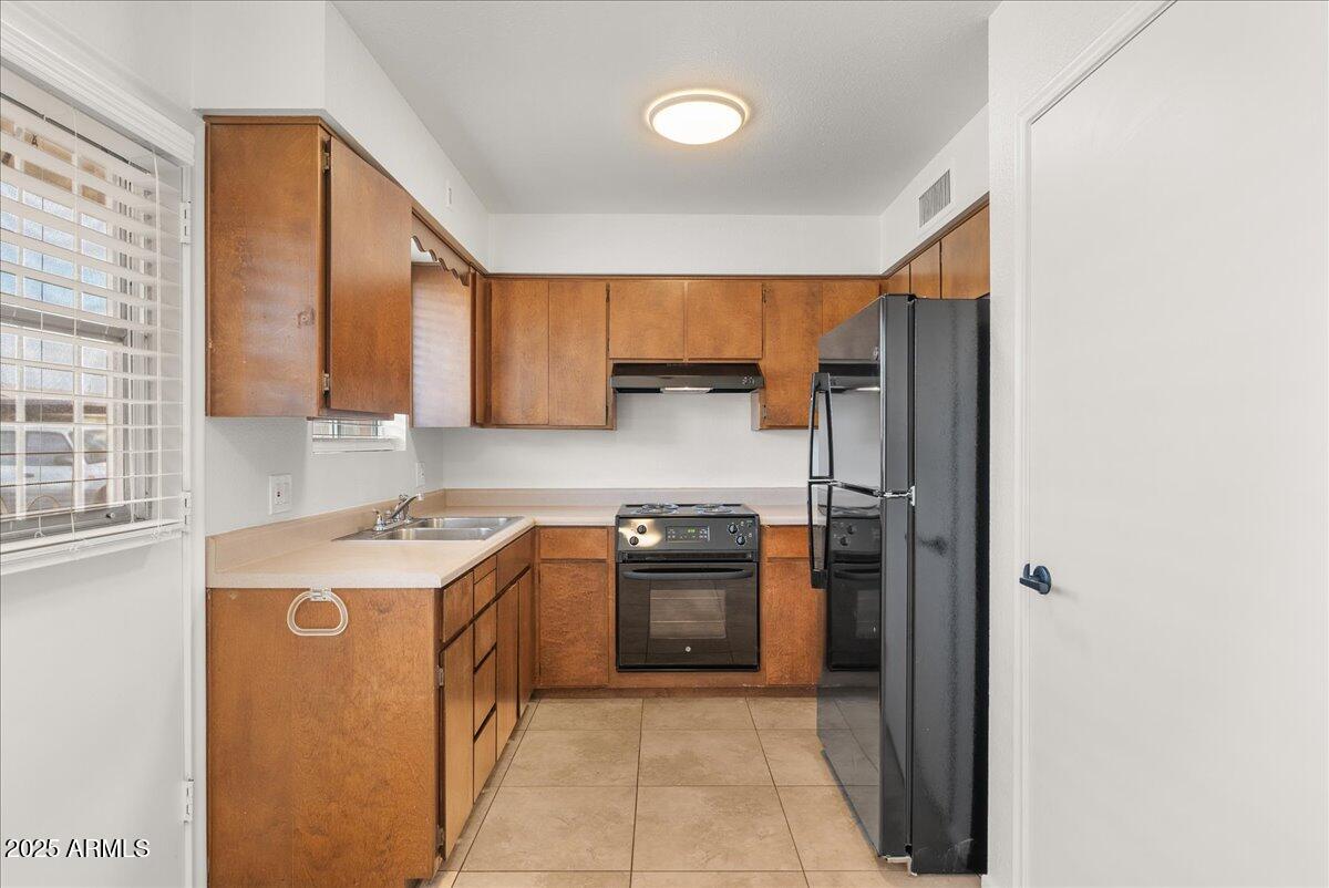 6438 East Butte Street, Unit 3 Mesa, AZ 85205 - Photo 10 of 24 a kitchen with stainless steel appliances granite countertop a stove a sink and a refrigerator