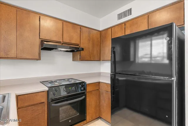 a kitchen with stainless steel appliances granite countertop a stove a sink and a refrigerator