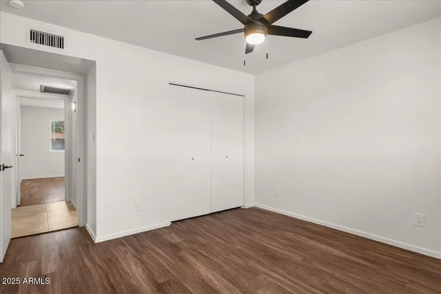 a view of a big room with wooden floor and windows