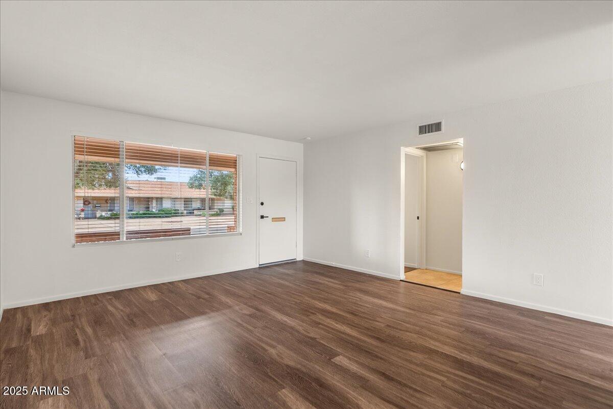 6438 East Butte Street, Unit 3 Mesa, AZ 85205 - Photo 6 of 24 a view of an empty room with wooden floor and a window