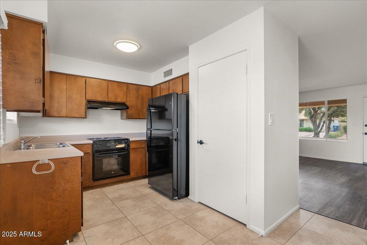 6438 East Butte Street, Unit 3 Mesa, AZ 85205 - Photo 9 of 24 a kitchen with stainless steel appliances granite countertop a refrigerator stove and sink