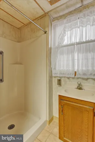 a view of an empty room and chandelier fan