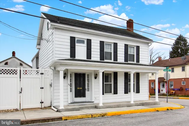 a view of a white building with swimming pool in front of it
