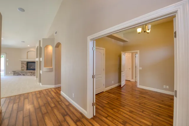 a view of a hallway with wooden floor and a living room