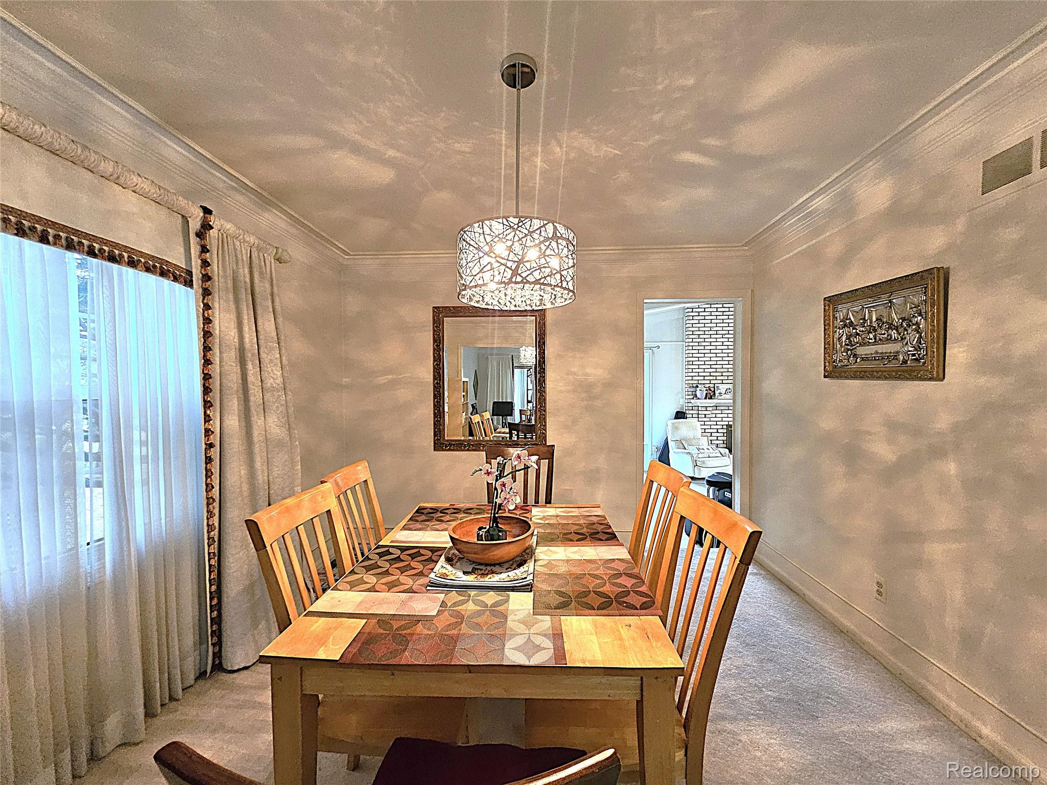 1114 Chaffer Drive Rochester, MI 48306 - Photo 28 of 50 Carpeted dining area featuring a modern pendant light fixture, crown molding, and a framed mirror