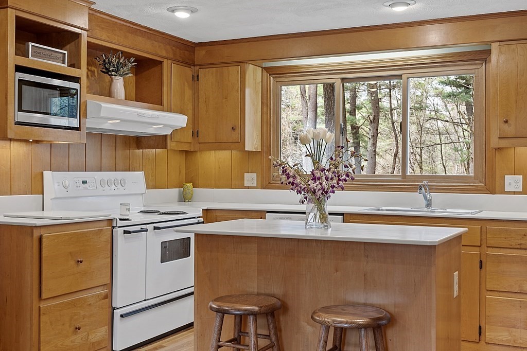 13 Eldridge Road Harvard, MA 01451 - Photo 12 of 40 a kitchen with stainless steel appliances granite countertop a stove a sink and a microwave