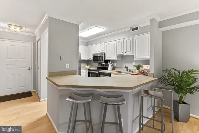 a kitchen with granite countertop a table chairs stove and cabinets