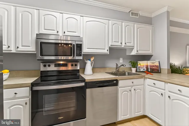 a kitchen with cabinets stainless steel appliances and a sink