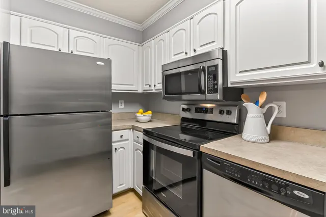a kitchen with granite countertop a refrigerator stove and microwave