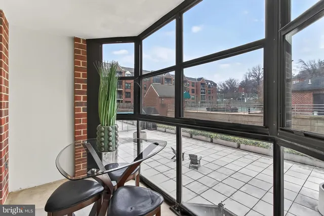 a view of an empty room with wooden floor and windows
