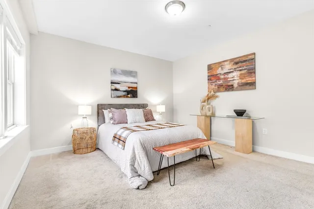 a bedroom with a bed and a large window