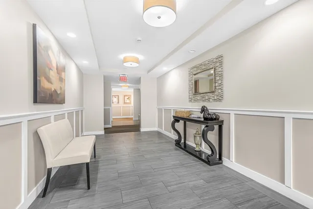 a spacious bathroom with a granite countertop sink a mirror and bathtub