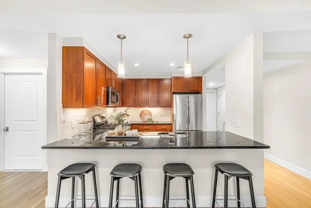 a kitchen with granite countertop a table chairs sink and wooden floor