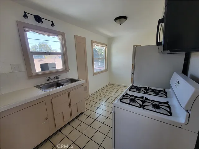 a kitchen with sink a stove and a refrigerator