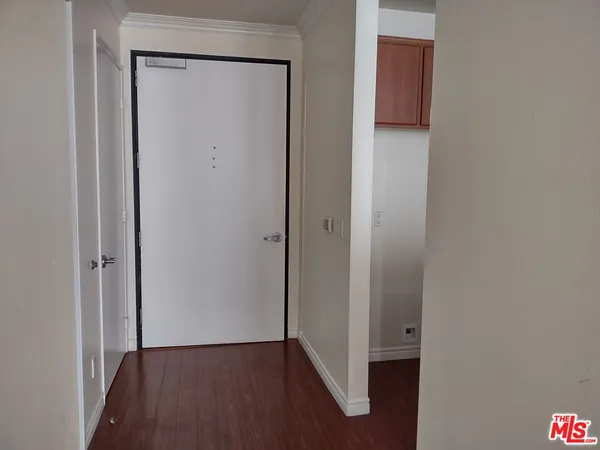 a view of an empty room with closet and wooden floor