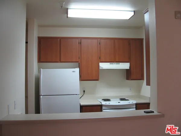 a kitchen with cabinets and a refrigerator