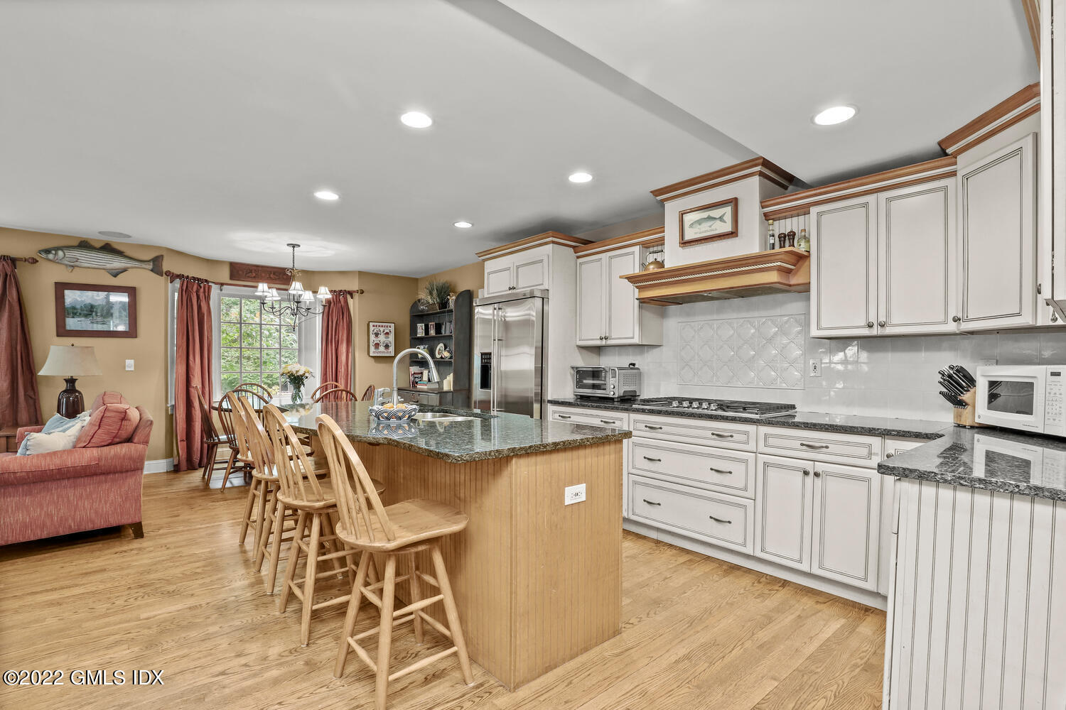 20 Crescent Road Riverside, CT 06878 - Photo 15 of 46 a kitchen with stainless steel appliances granite countertop a stove top oven a sink dishwasher and white cabinets with wooden floor