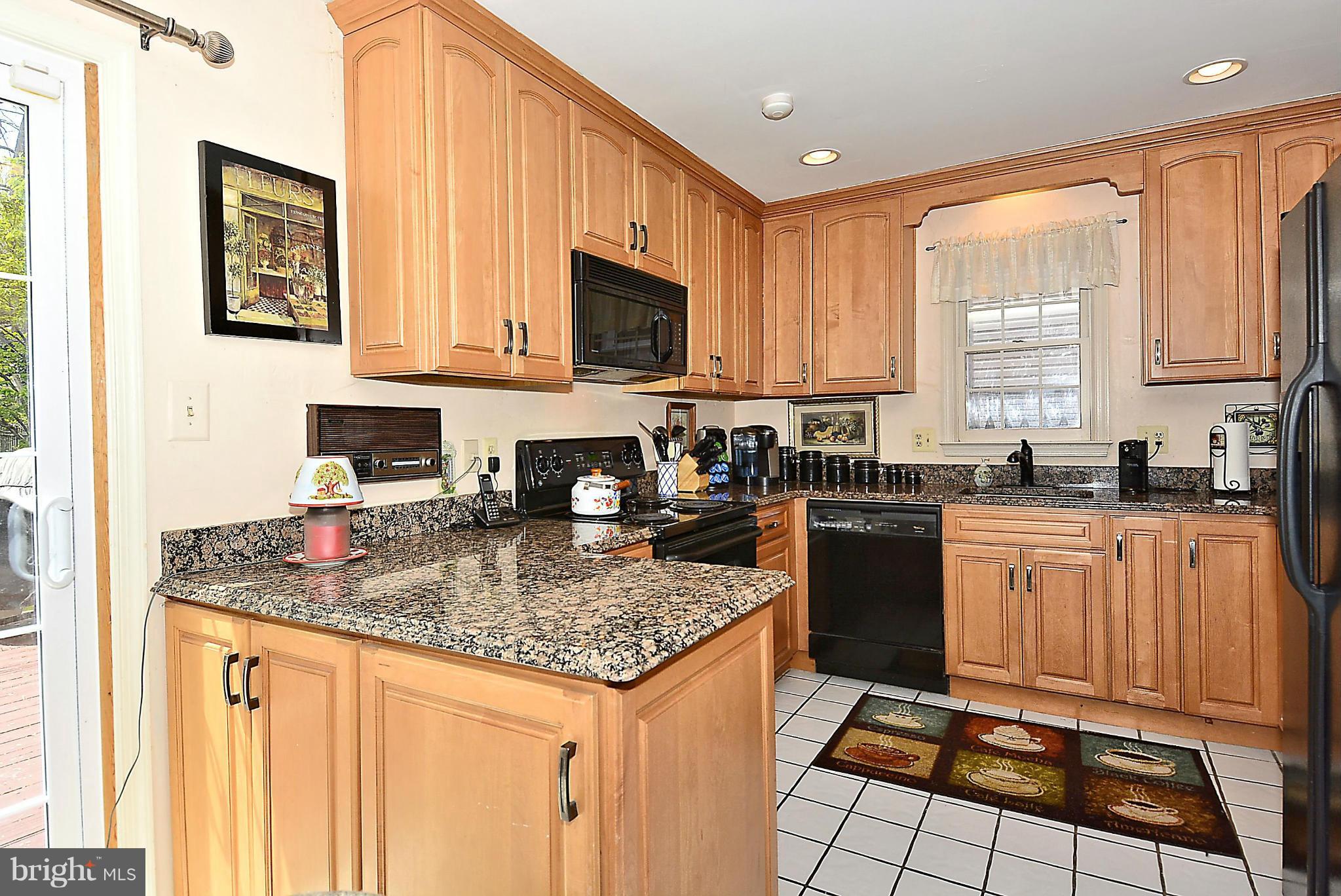 10404 Mountain Quail Road Silver Spring, MD 20901 - Photo 8 of 30 a kitchen with stainless steel appliances granite countertop a stove sink and cabinets