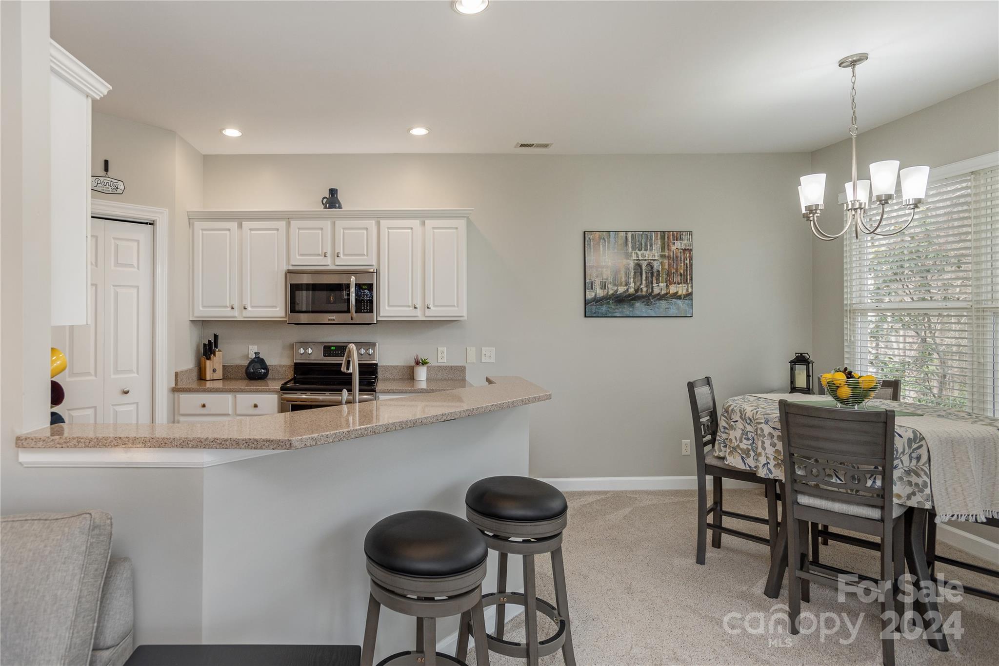 99 Ridgetop Circle, Unit 203 Brevard, NC 28712 - Photo 8 of 36 a kitchen with stainless steel appliances granite countertop a dining table chairs stove top oven and sink