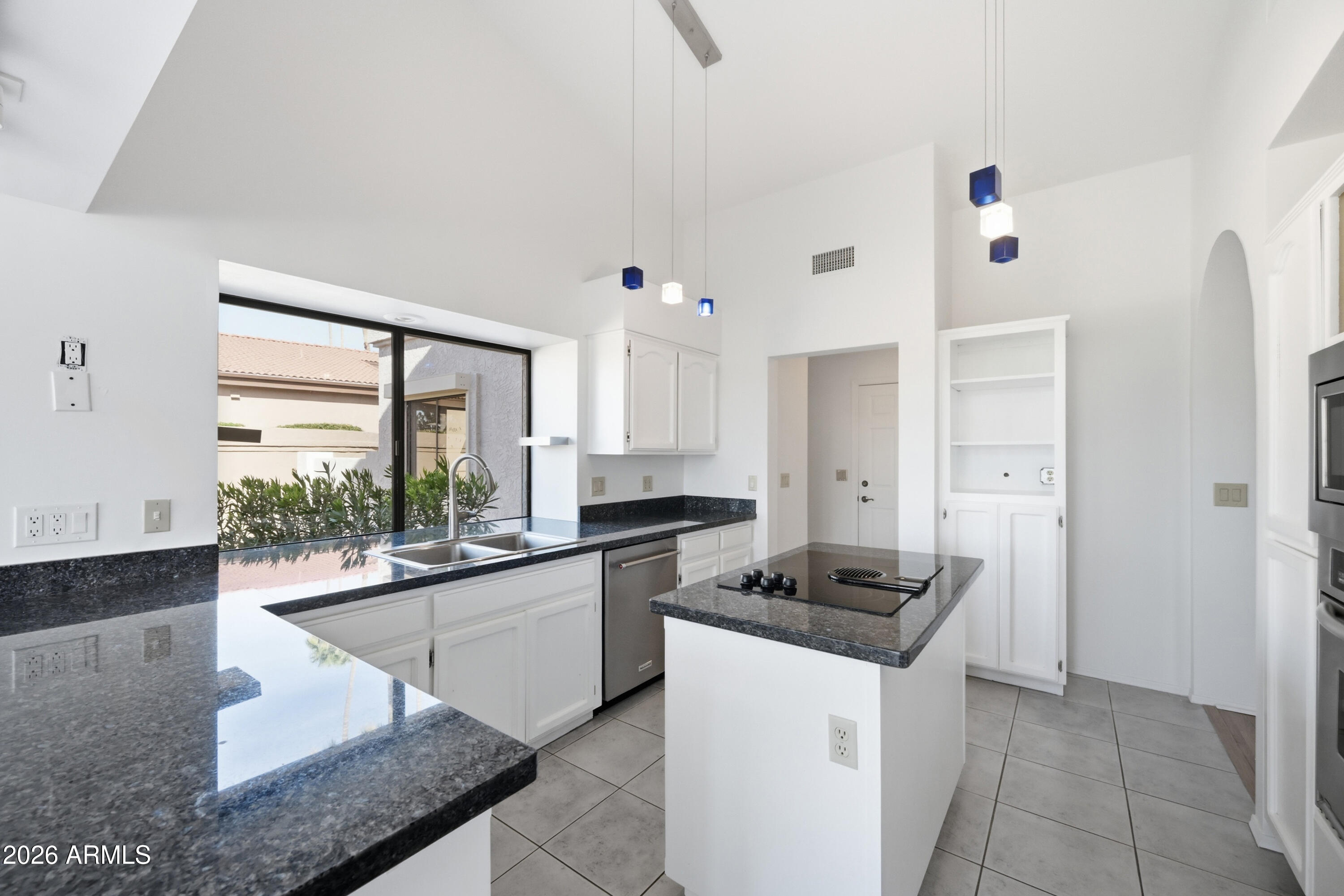 19113 East Vía Esquina Rio Verde, AZ 85263 - Photo 12 of 44 a kitchen with granite countertop a stove and white cabinets