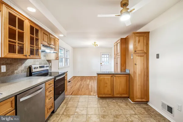 a large kitchen with stainless steel appliances granite countertop a refrigerator and a sink