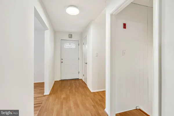 a view of a livingroom with wooden floor and a bathroom
