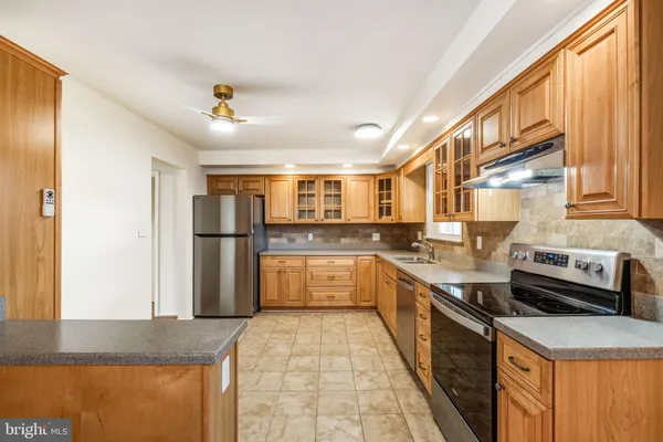 a kitchen with stainless steel appliances granite countertop a stove a sink and a refrigerator